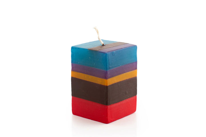 2" x 2" x 3" Memphis Stripe cube candle. Handmade and hand painted with stripes of assorted colors, turquoise, golden yellow, burnt orange, purple, dark green, brown & beige.