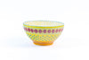 Ceramic serving bowl with base color of yellow. Dots & Stripes painted on top in fun colors of jasper green, turquoise, orange & red. White inside the bowl.