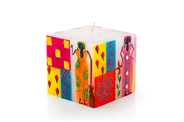 African Ladies 3" x 3" x 3" cube candle. The design has a white background with different African Ladies painted on the sides - with attitude! Each in a colorful frock with arm up or on hips. Fair Trade. 