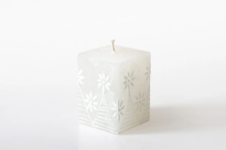 2" x 2" x 3" White on white cube candle. The designs include floral or graphic patterns painted in white on a white candle.  Lovely as they burn as the candle lights from within and shows the artistry on the candle.